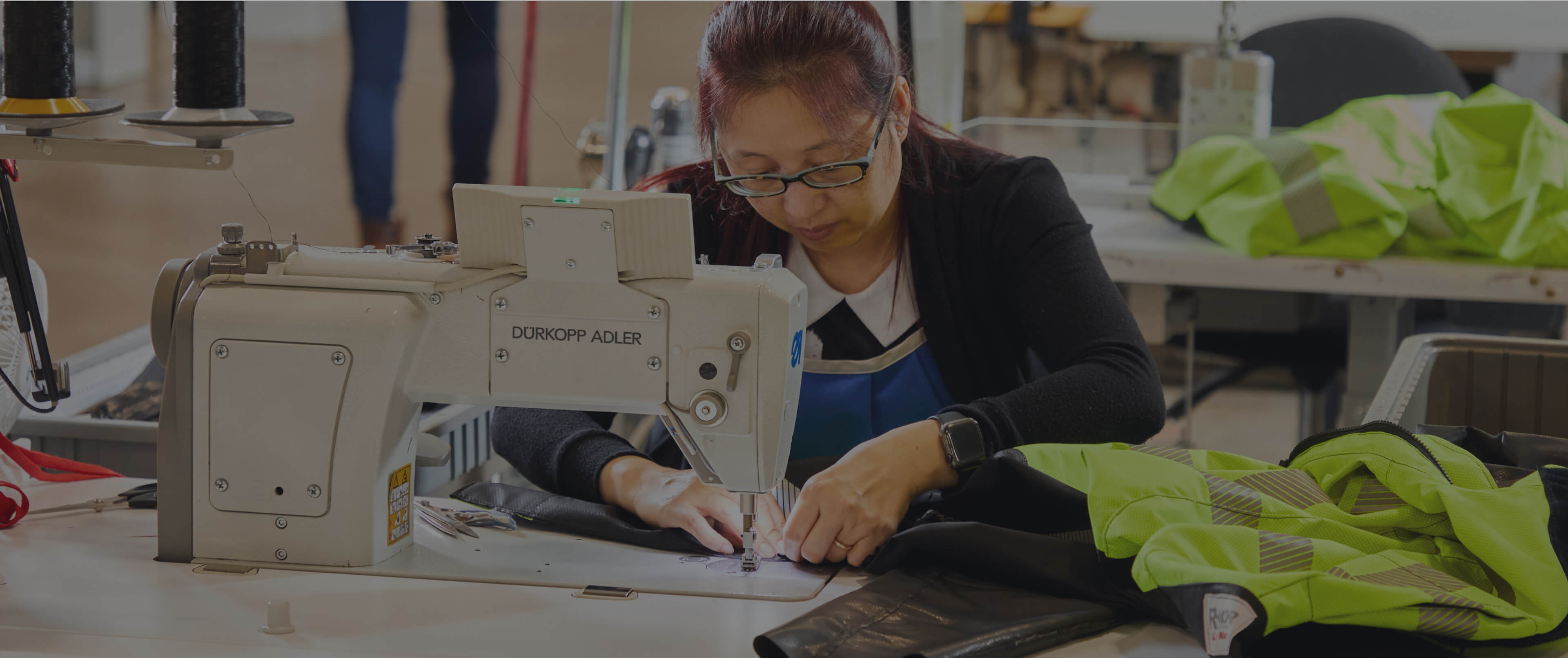 A worker at Lac Mac factory is sewing PPE.